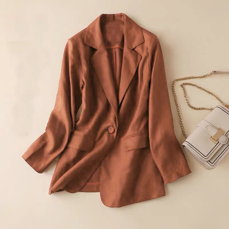 Chất liệu linen khiến chiếc áo blazer nâu trầm thêm phần mềm mại, thanh lịch